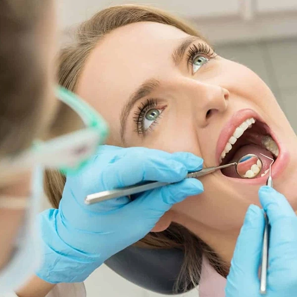 معاینه فک پایین و سلامت لثه ها توسط دندانپزشک